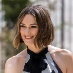 Une femme souriante, la cinquantaine, arbore une coupe dégradée qui donne du volume à ses cheveux fins et plats.