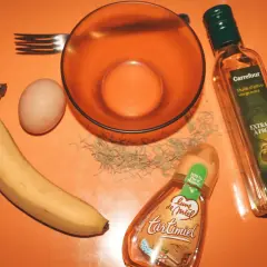 Ingrédients pour un masque cheveux secs et abîmés maison : banane, œuf, huile d'olive, miel et romarin.