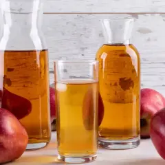 Pommes rouges et carafes de vinaigre de cidre, un ingrédient naturel pour savoir quel vinaigre pour les cheveux.