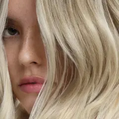 Un visage féminin aux cheveux blonds, une inspiration pour un cercle chromatique coiffure.