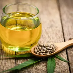 Verre d'huile de chanvre et cuillère de graines. Un ingrédient naturel pour la pousse des cheveux.