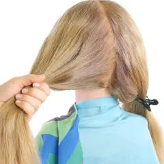 Main d'une femme tenant une mèche de cheveux blonds pour commencer une tresse hollandaise.