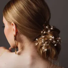 Coiffure soirée simple cheveux long, ornée d'une branche dorée avec perles et feuilles. Une touche d'élégance pour une occasion spéciale.
