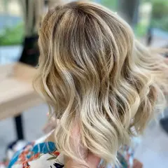 Chevelure blonde ondulée, aux reflets subtils, un bel effet ton sur ton.