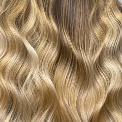 Chevelure blonde ondulée, aux reflets miel et dorés. Est-ce que la patine abîme les cheveux ? Cette patine semble sublimer la chevelure sans l'abîmer.