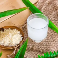 Un bol de riz cru et un verre d'eau de riz, parfaits pour des cheveux brillants.