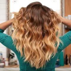 Cheveux longs ondulés avec un dégradé blond obtenu par décoloration cheveux maison.