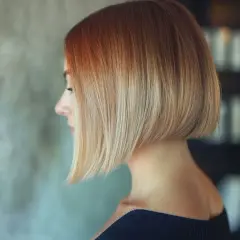 Profil d'une femme avec un carré très court derrière, dégradé du roux au blond.