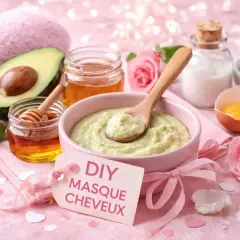 Un bol de masque cheveux maison à l'avocat et au miel, avec des roses roses et des cœurs.