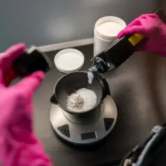 Mélange d'une poudre décolorante avec un oxydant 10 pour éclaircir les cheveux.