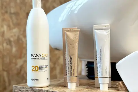 Produits de coloration capillaire : un flacon d'oxydant 20 volumes, deux tubes de coloration, l'un "sans ammoniaque", l'autre "enrichie en kératine et huile d'argan".