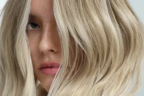 Un visage féminin aux cheveux blonds, une inspiration pour un cercle chromatique coiffure.