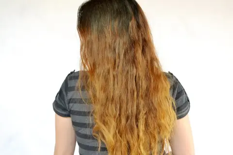 Cheveux longs et ondulés, décolorés par le soleil, comme un effet citron cheveux avant après.