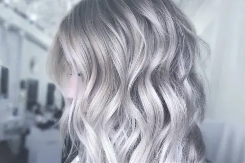 Une chevelure aux reflets argentés, une patine cheveux blanc parfaite pour un look moderne et audacieux.