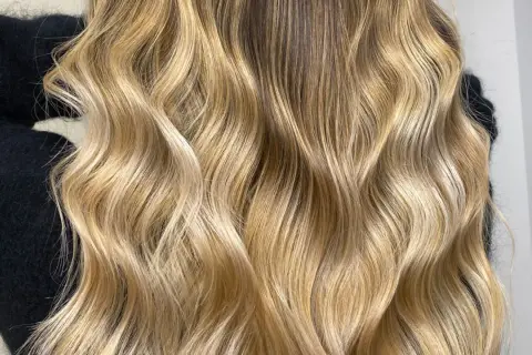 Chevelure blonde ondulée, aux reflets miel et dorés. Est-ce que la patine abîme les cheveux ? Cette patine semble sublimer la chevelure sans l'abîmer.