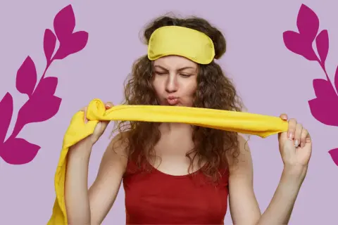 Une femme aux cheveux bouclés, portant un masque de nuit jaune, tient un tissu jaune. Elle semble prête pour une coiffure protectrice nuit.