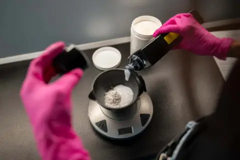 Mélange d'une poudre décolorante avec un oxydant 10 pour éclaircir les cheveux.