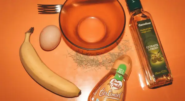 Ingrédients pour un masque cheveux secs et abîmés maison : banane, œuf, huile d'olive, miel et romarin.