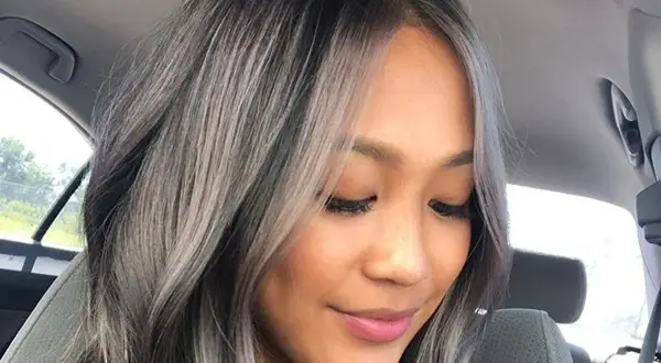 Une femme avec un balayage blanc sur cheveux noir, un style audacieux et moderne.