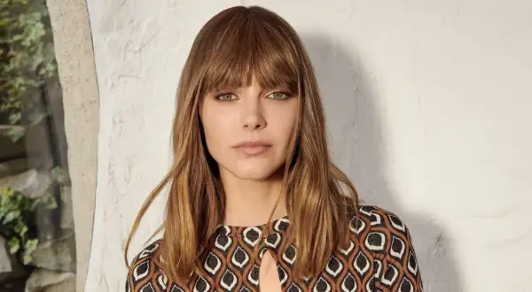 Tuto frange rideau : une femme aux cheveux châtains et aux yeux verts, portant une robe à motifs géométriques.