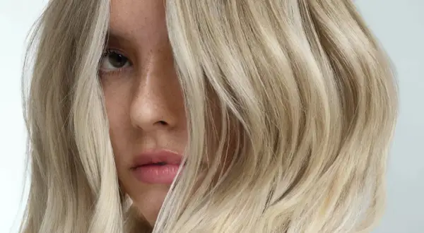 Un visage féminin aux cheveux blonds, une inspiration pour un cercle chromatique coiffure.
