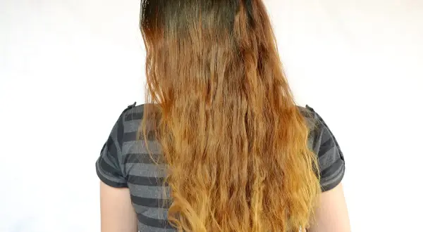 Cheveux longs et ondulés, décolorés par le soleil, comme un effet citron cheveux avant après.