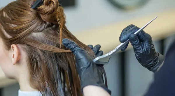 Application d'un soin capillaire sur des cheveux bruns avec une brosse.