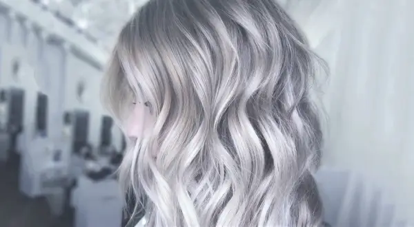 Une chevelure aux reflets argentés, une patine cheveux blanc parfaite pour un look moderne et audacieux.