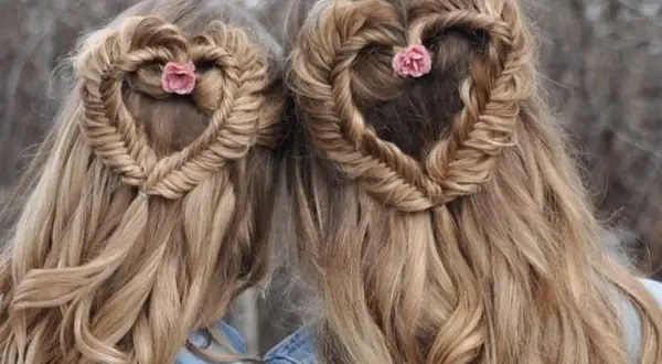 Deux coiffures cheveux longs femme en forme de cœur tressé, ornées de petites fleurs roses.