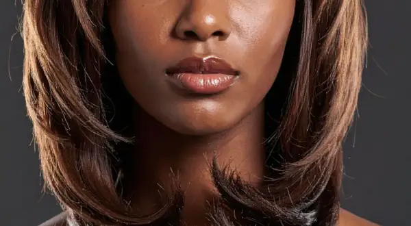 Gros plan sur le visage d'une femme avec un carré dégradé, des lèvres pulpeuses et brillantes.