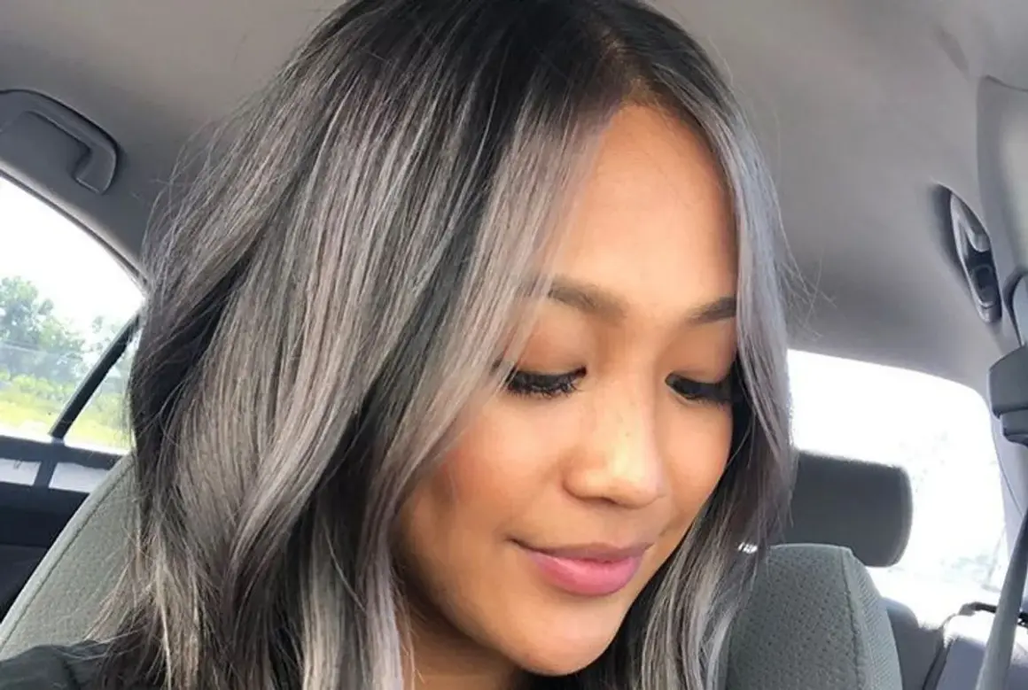 Une femme avec un balayage blanc sur cheveux noir, un style audacieux et moderne.