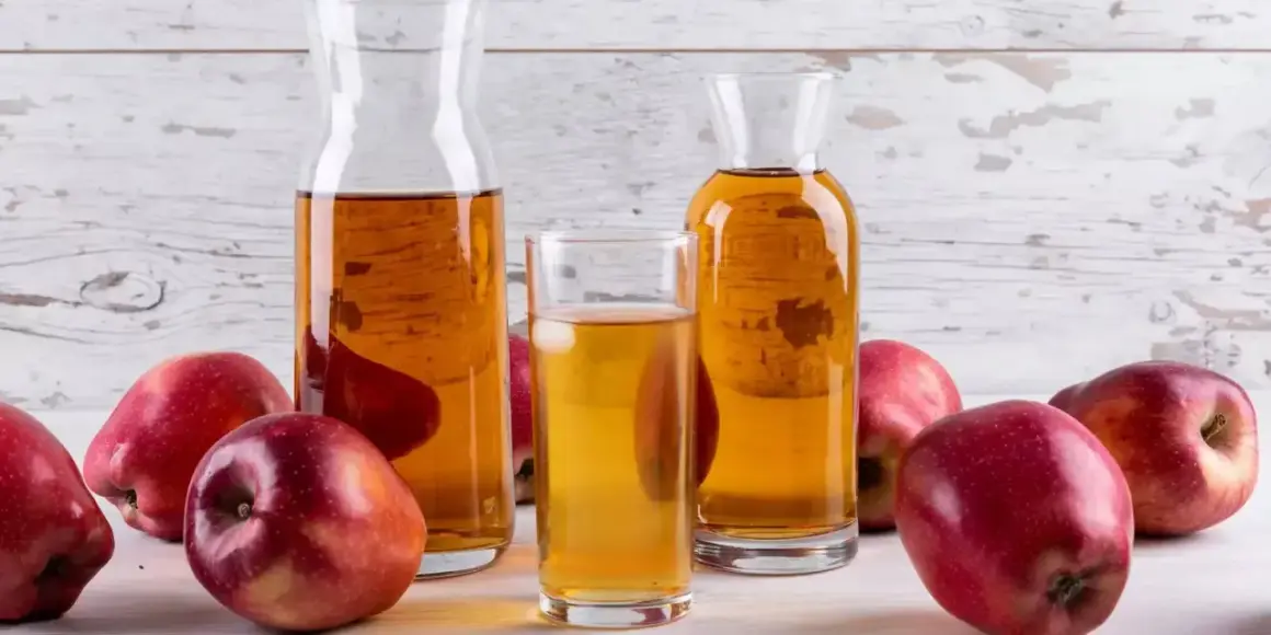 Pommes rouges et carafes de vinaigre de cidre, un ingrédient naturel pour savoir quel vinaigre pour les cheveux.