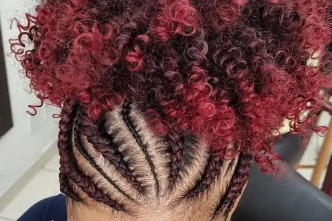 Tresses collées sur le cuir chevelu, contrastant avec une chevelure bouclée rouge et noire.
