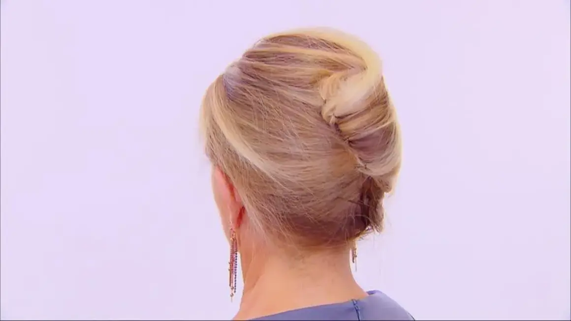 Vue arrière d'une femme aux cheveux blonds coiffés en chignon banane moderne.