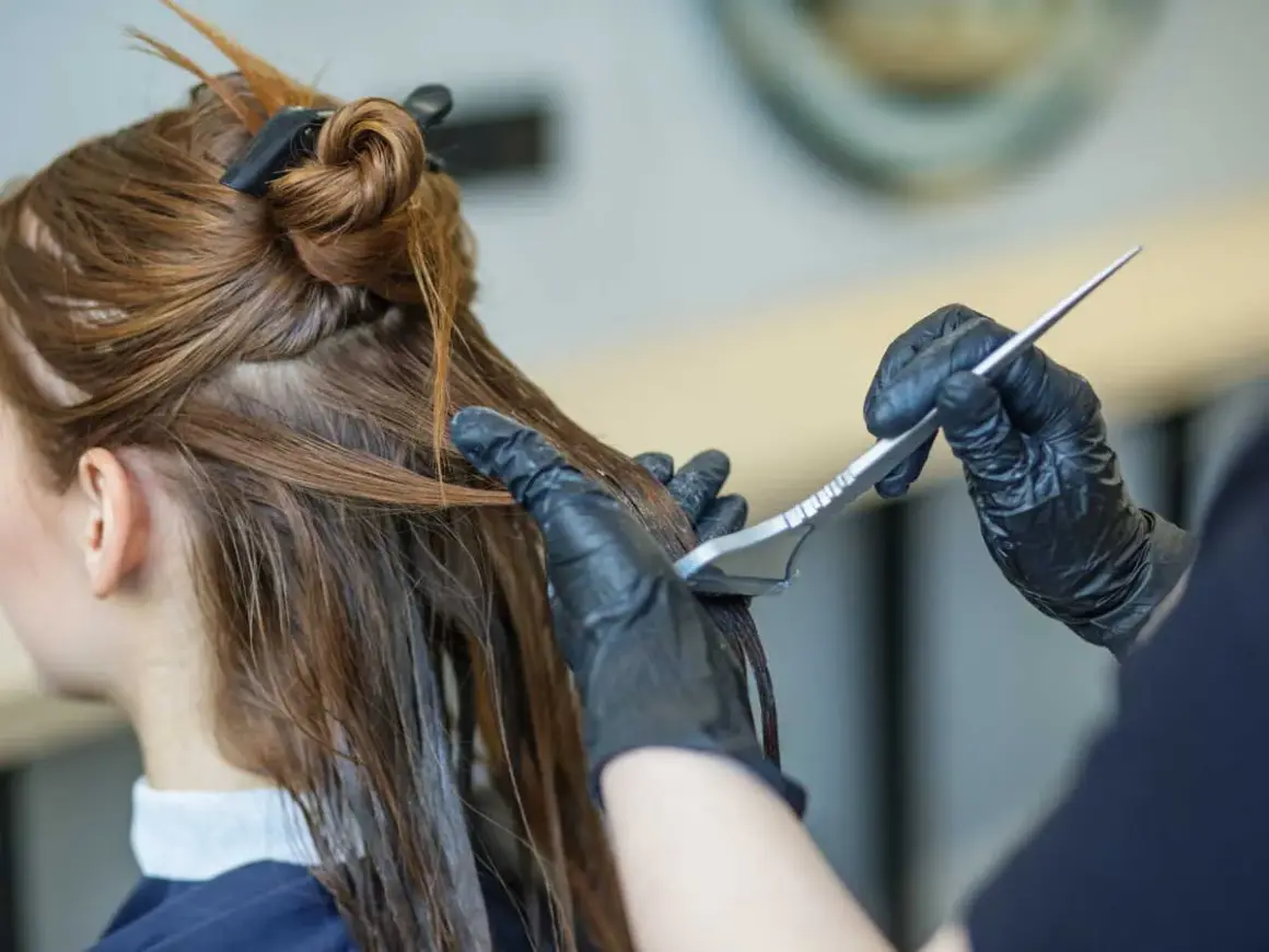 Application d'un soin capillaire sur des cheveux bruns avec une brosse.