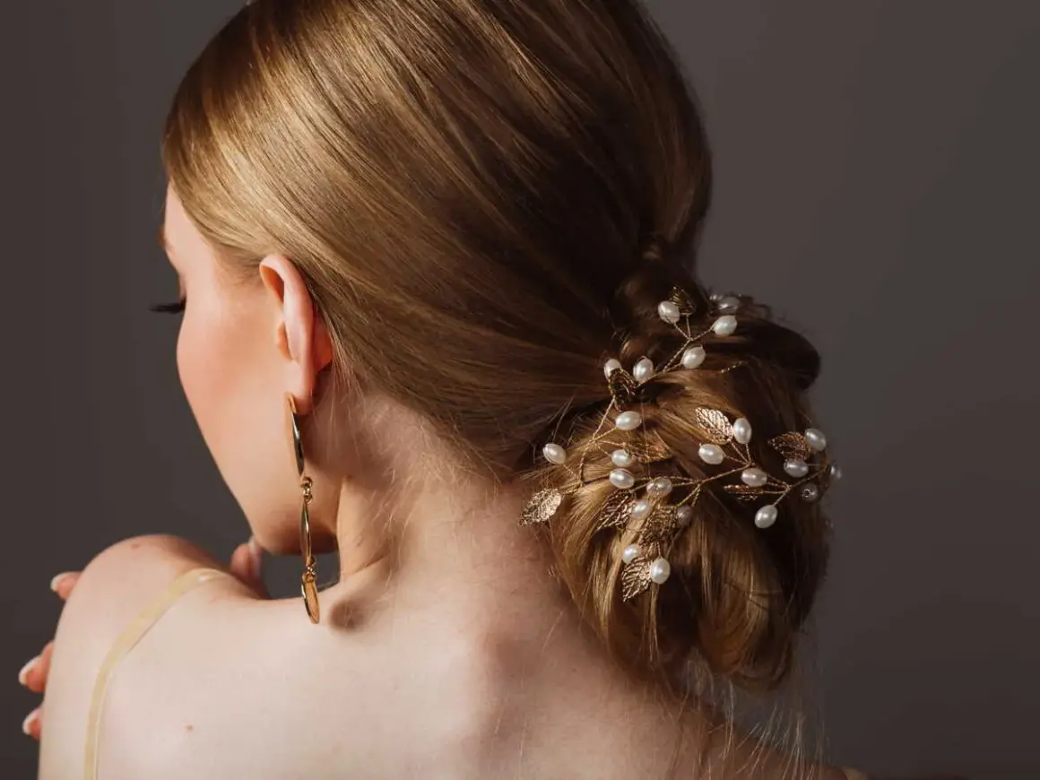 Coiffure soirée simple cheveux long, ornée d'une branche dorée avec perles et feuilles. Une touche d'élégance pour une occasion spéciale.