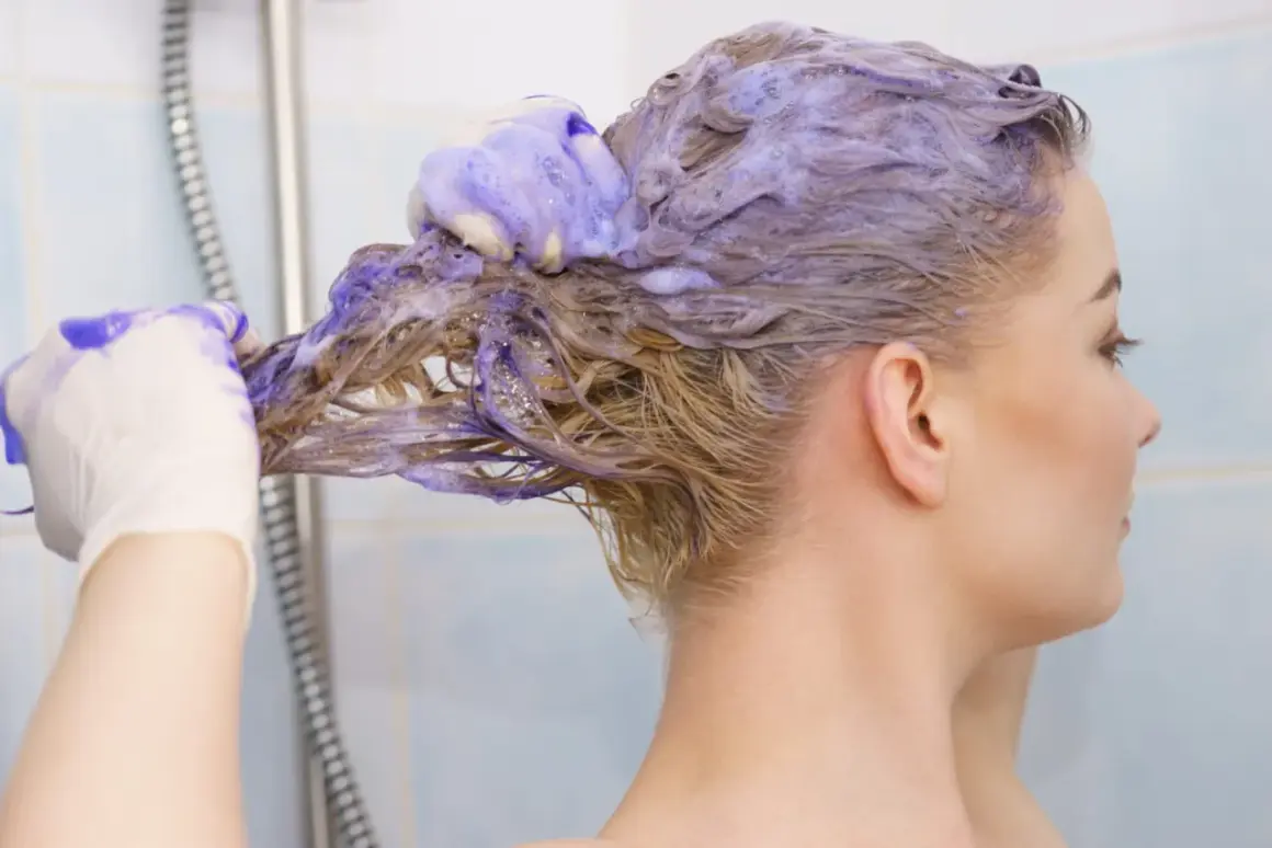 Une femme se lave les cheveux avec du shampoing bleu. Elle porte des gants pour savoir comment enlever le shampoing bleu sur les cheveux.