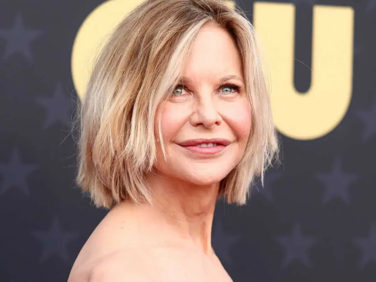 Une femme de 50 ans avec une coupe courte et d&eacute;grad&eacute;e, parfaite pour des cheveux fins et plats, souriant l&eacute;g&egrave;rement.