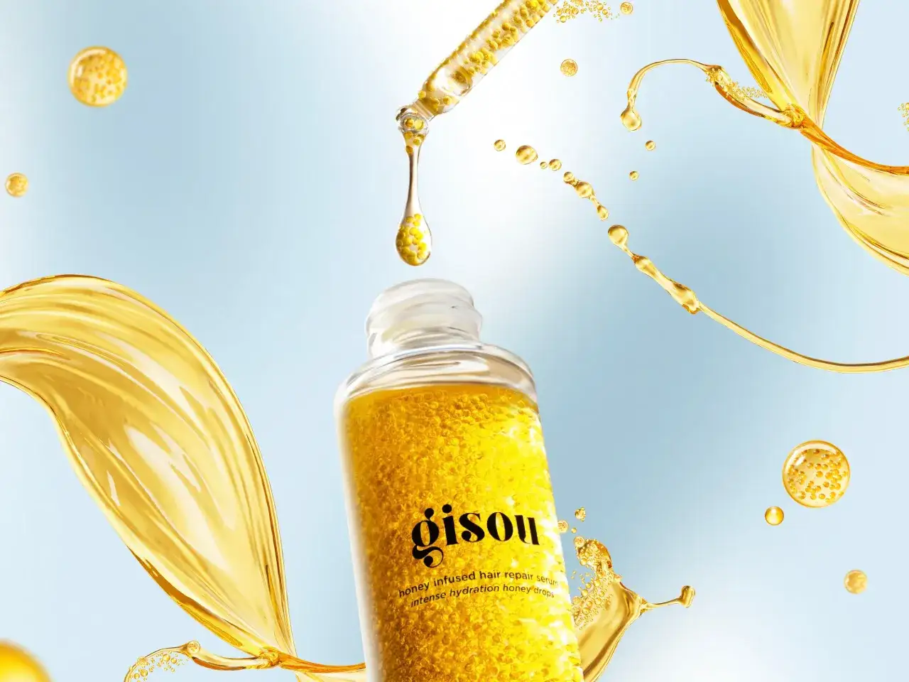 Gisou s&eacute;rum miel, une goutte tombe d'une pipette. D&eacute;couvrez comment appliquer un s&eacute;rum pour des cheveux &eacute;clatants.