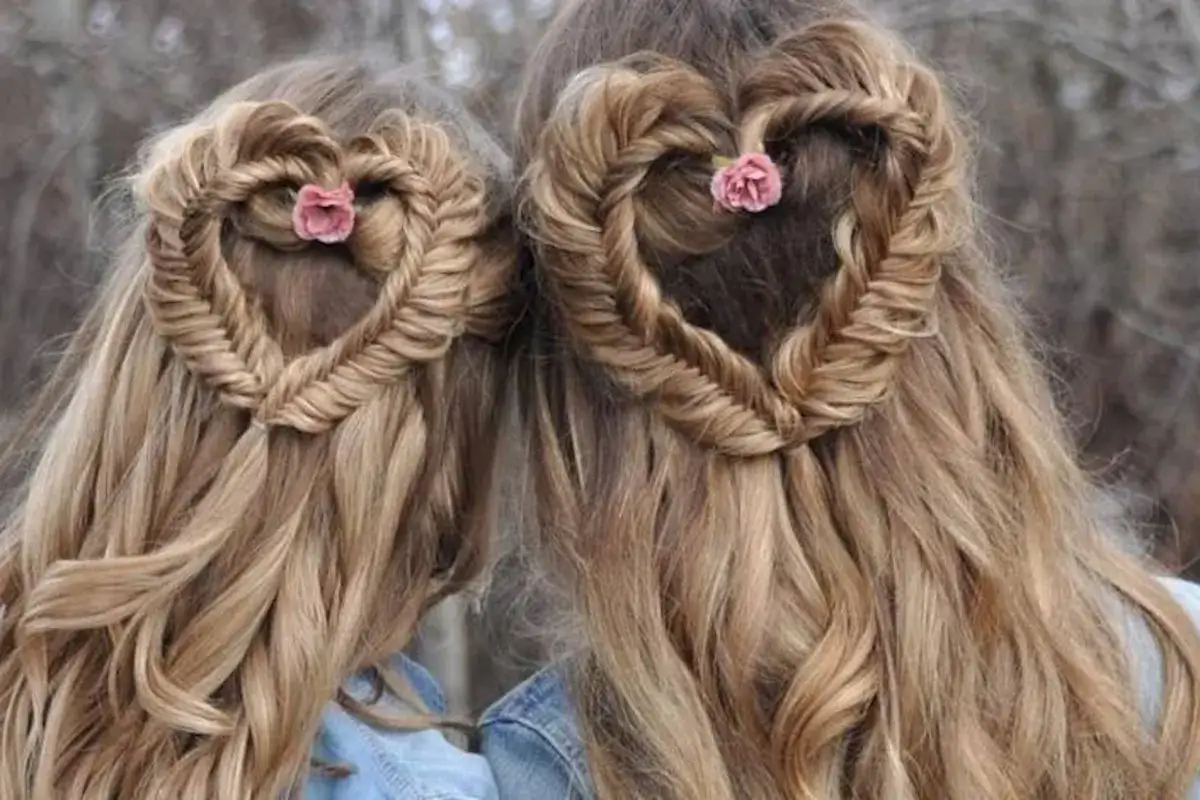 Deux coiffures en forme de cœur, une tresse simple ornée de petites fleurs roses.