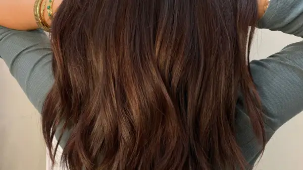 Chevelure brune aux reflets chauds, une patine subtile pour un look naturel.