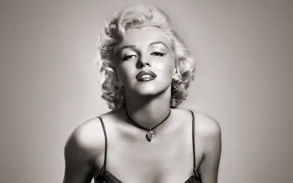 Icône glamour avec une coiffure année 50, maquillage marqué et un collier en forme de cœur.